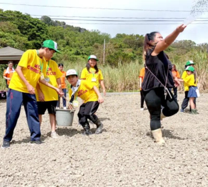 7月18日、イオン南風原チアーズクラブが八重瀬町富盛の島袋農園で緑肥の種まきや水やりを体験し農業や環境を学ぶ