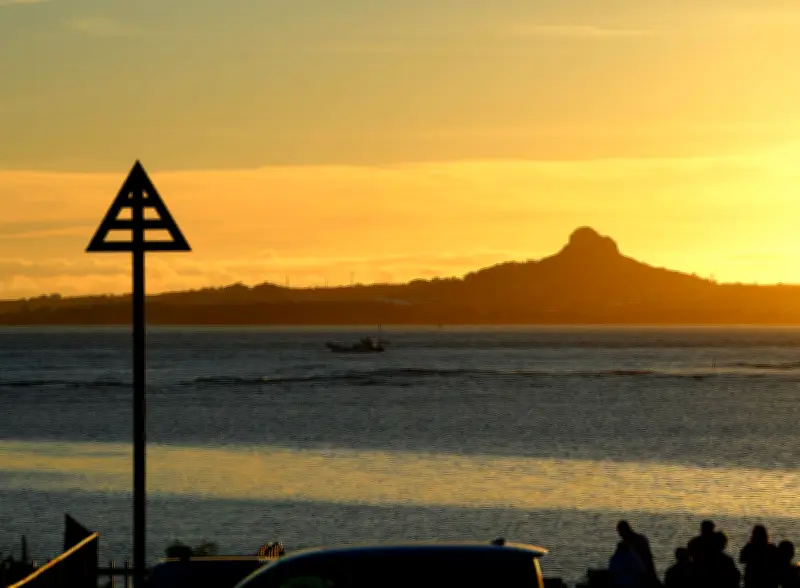 海洋博花火大会開始を待つ夕暮れ時、対岸の伊江島タッチューのシルエットがひときわ存在感を増す（本部町備瀬）