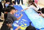 障がいある子ら約70人がキャンバスに「みんなの海」描く 嘉手納