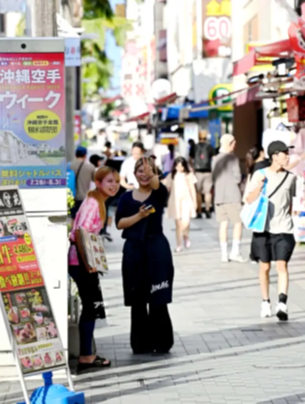 真夏の西日が照らす国際通り、日陰で笑顔の店員さん