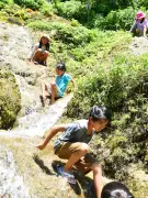炎天下の子どもたちが湧き水の岩場で遊ぶ 南城市・垣花樋川